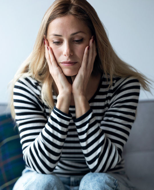 Mujer pensando si acudir a terapia por ansiedad.